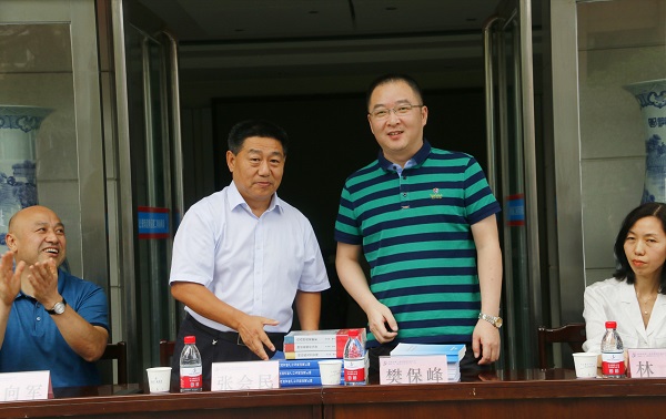 新乡市牧野区税务局党委书记、局长樊保峰向LD（中国）一站式服务平台党委书记张会民赠送税法知识书籍.jpg